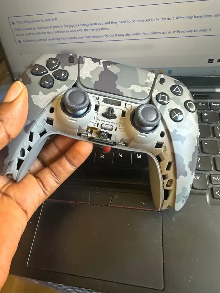 Camo DualSense controller connected to a laptop for stick drift diagnosis