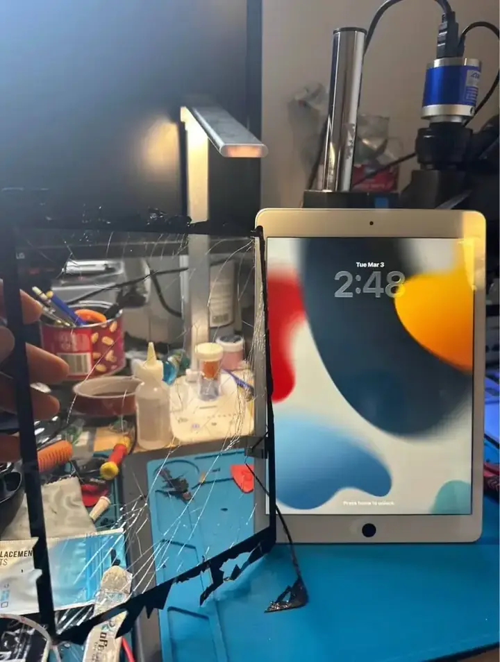 Cracked iPad digitizer removed beside the repaired iPad after screen replacement