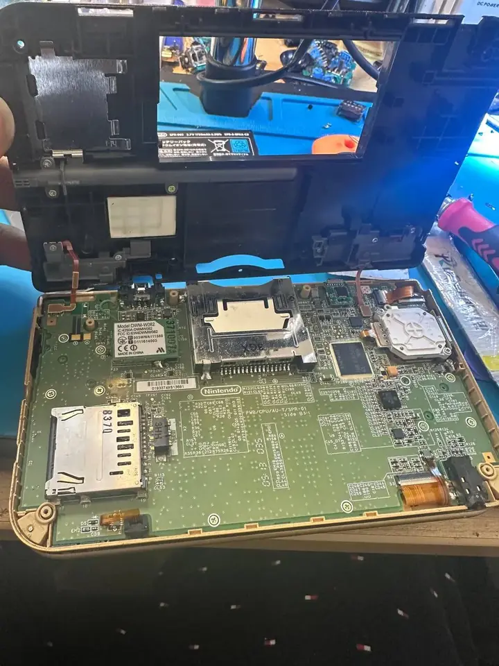 Nintendo 3DS XL opened with its motherboard exposed for repair