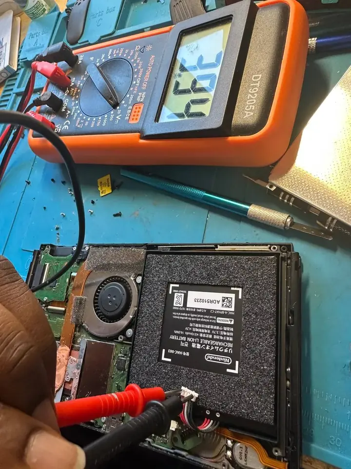 Multimeter testing the battery voltage of an opened Nintendo Switch