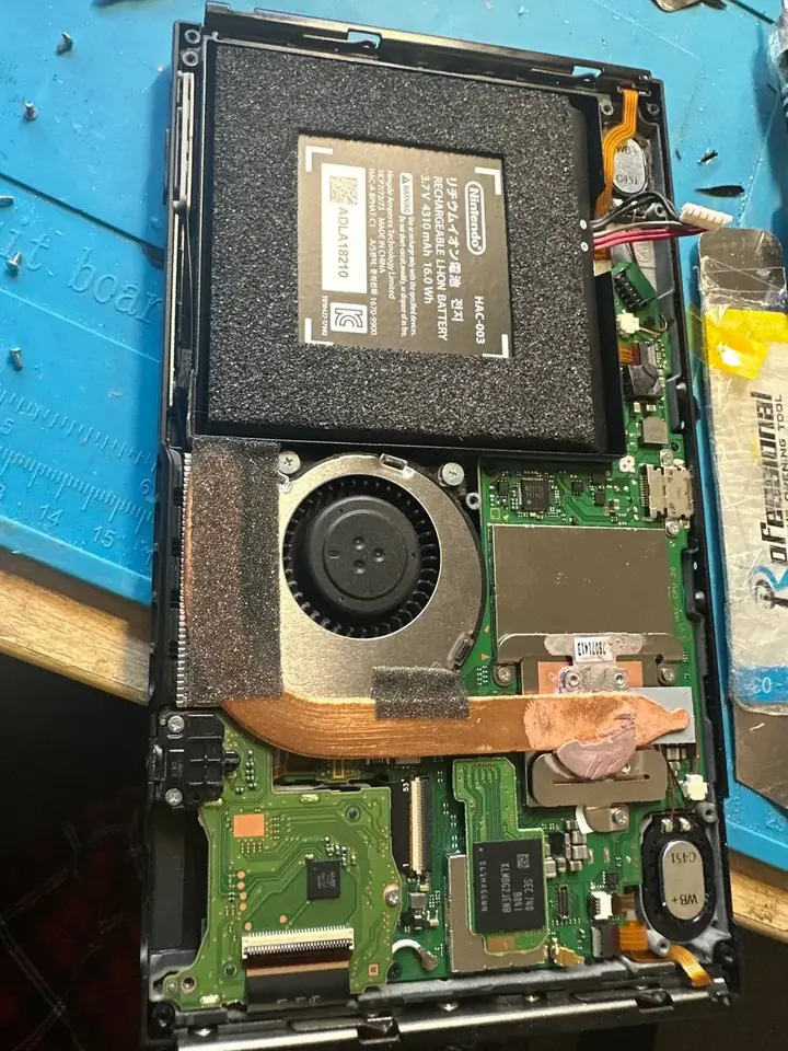 Opened Nintendo Switch with the copper heatpipe and processor shield showing old thermal paste