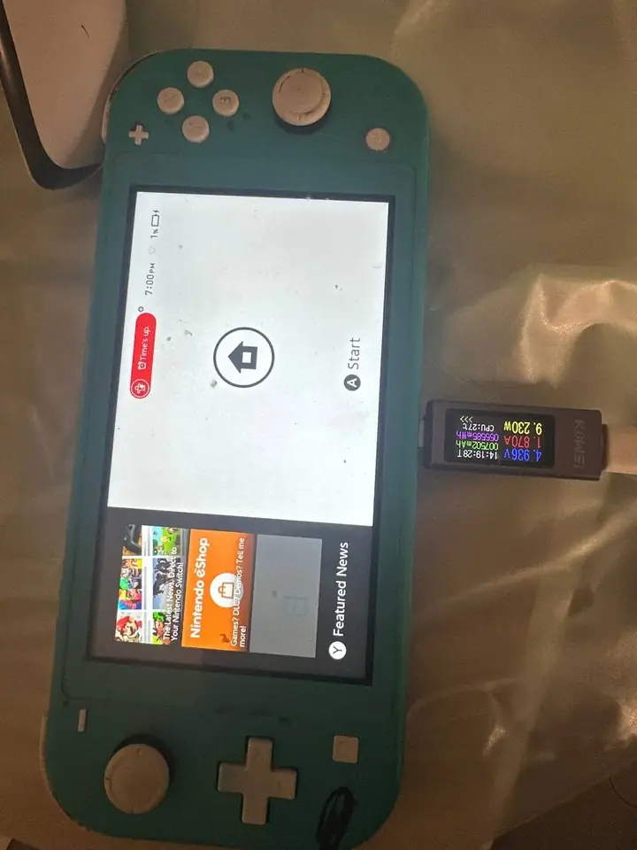 Turquoise Nintendo Switch Lite charging on a USB meter after a charging port repair