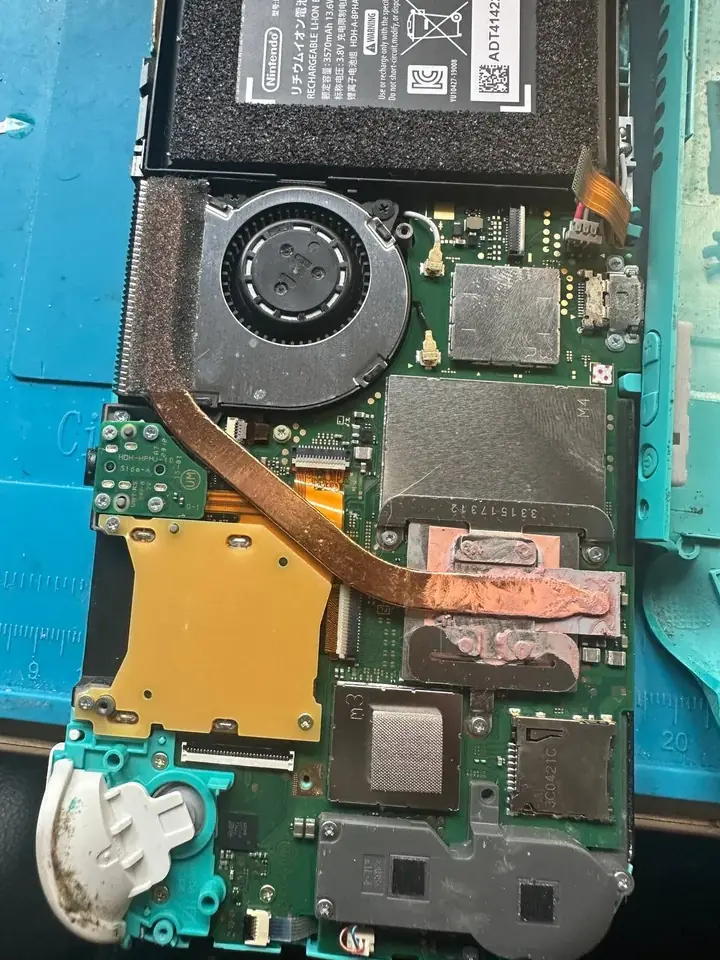 Nintendo Switch Lite motherboard and heatpipe exposed during repair