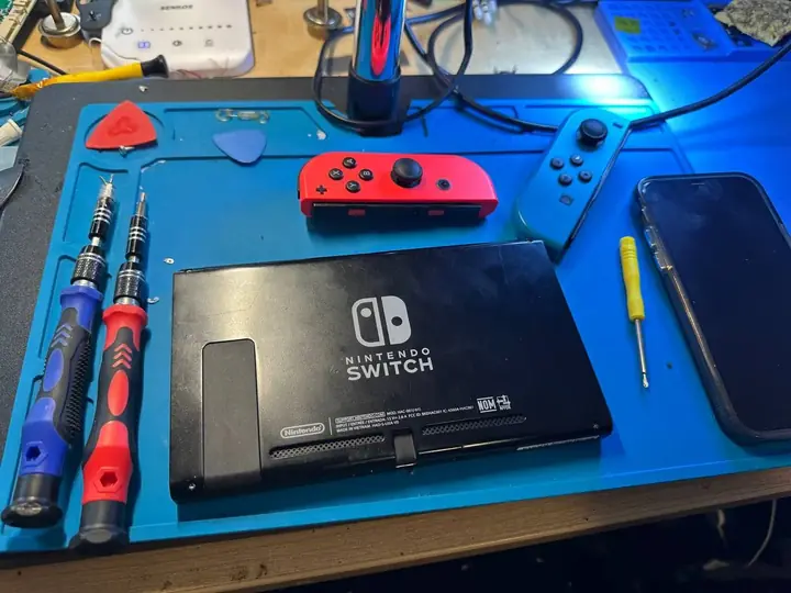 Nintendo Switch console and red and blue Joy-Con controllers on the FlexRepairs Oshawa repair bench