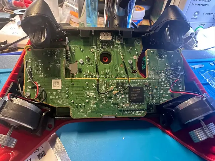 Xbox Series controller opened on the bench with its motherboard exposed for joystick replacement