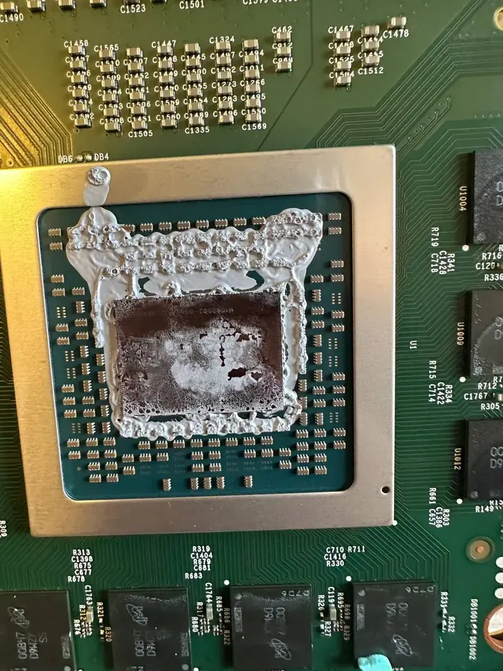 Xbox Series X APU covered in old, dried thermal compound before cleaning